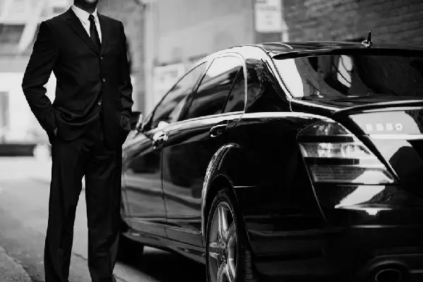 Executive chauffeur opening a car door